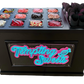 A black candy and sweets station display case with a neon-style 'Tempting Sweets' sign on the front. The top surface holds multiple clear plastic bins filled with assorted colorful candies, sweets, and pink cone stands, photographed on a plain white background.